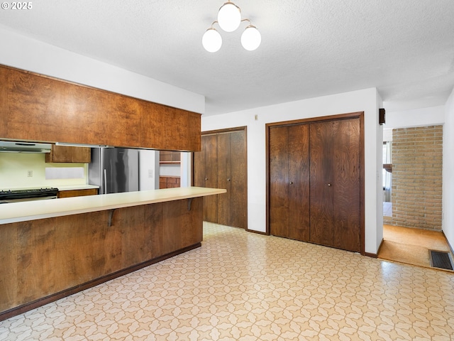 15416 NE Holladay St, Portland, OR 97230 - kitchen with light countertops, light floors, extractor fan, and stainless steel appliances