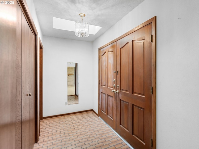 15416 NE Holladay St, Portland, OR 97230 - entryway featuring an inviting chandelier, baseboards, and brick patterned floor