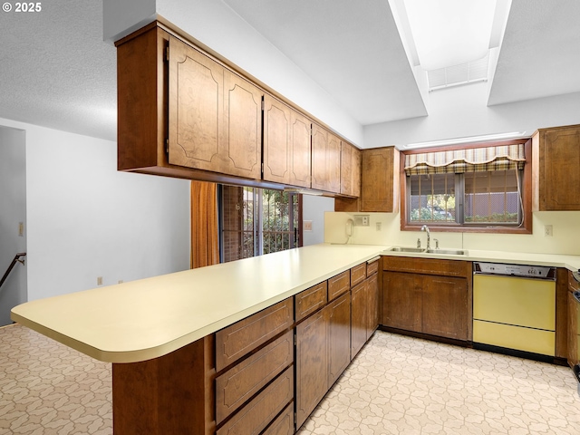 15416 NE Holladay St, Portland, OR 97230 - kitchen featuring a peninsula, light floors, dishwashing machine, light countertops, and a sink