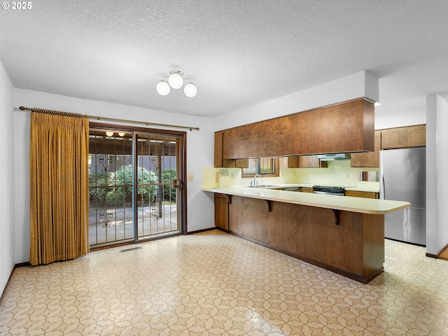 15416 NE Holladay St, Portland, OR 97230 - kitchen with baseboards, light countertops, appliances with stainless steel finishes, and a peninsula
