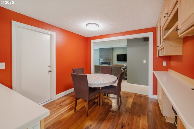 1378 SW Taylors Ferry Ct, Portland, OR 97219 - dining space with wood-type flooring, a textured ceiling, and a fireplace