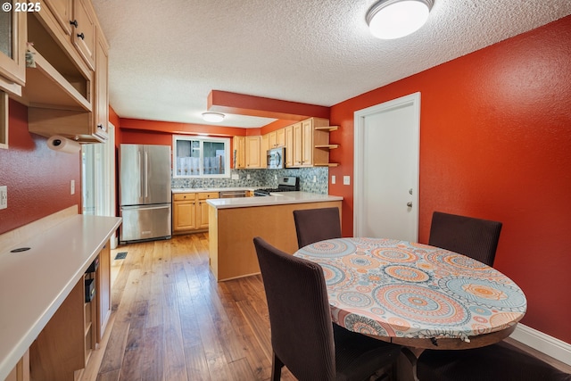 1378 SW Taylors Ferry Ct, Portland, OR 97219 - kitchen featuring appliances with stainless steel finishes, light wood-type flooring, open shelves, a peninsula, and light countertops