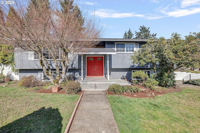 view of front of house with fence and a front lawn