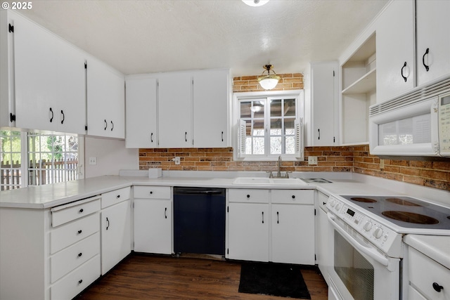 kitchen featuring a peninsula, white appliances, dark wood-style flooring, a sink, and open shelves