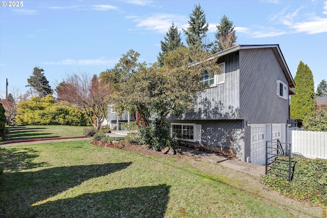 view of yard featuring an attached garage and fence