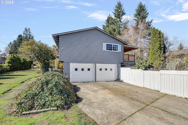 view of side of property featuring concrete driveway, fence, and an attached garage