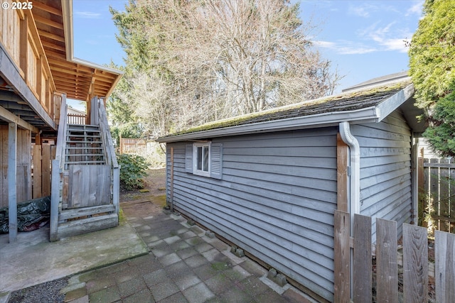 view of side of property featuring stairs, fence, and a patio