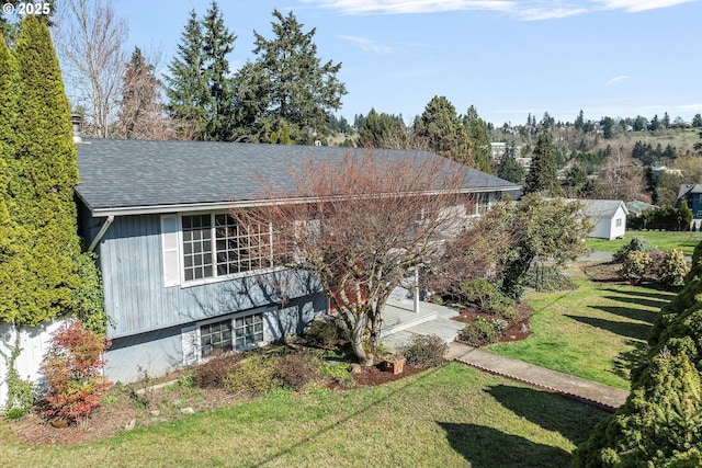 view of front facade featuring a front lawn and roof with shingles