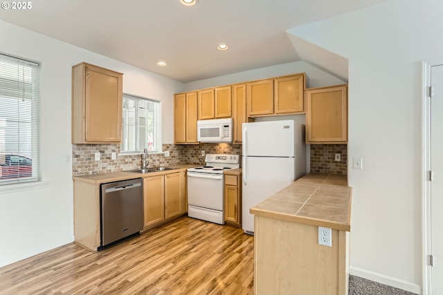 kitchen featuring decorative backsplash, light brown cabinets, white appliances, a sink, and light wood-style flooring
