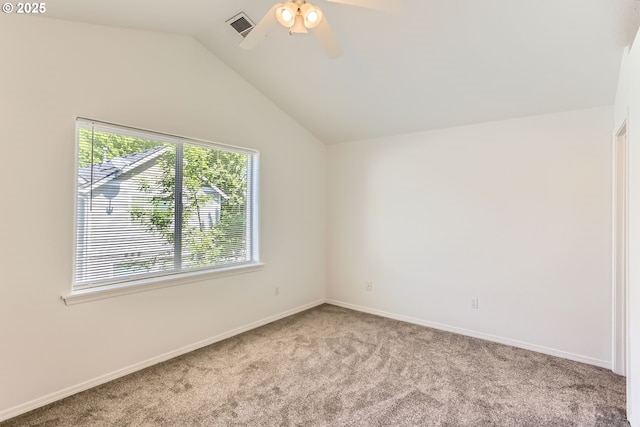 spare room featuring carpet flooring, ceiling fan, baseboards, lofted ceiling, and visible vents