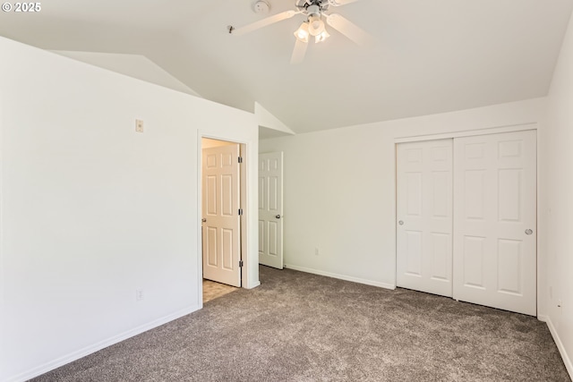 unfurnished bedroom with carpet floors, a closet, lofted ceiling, baseboards, and ceiling fan