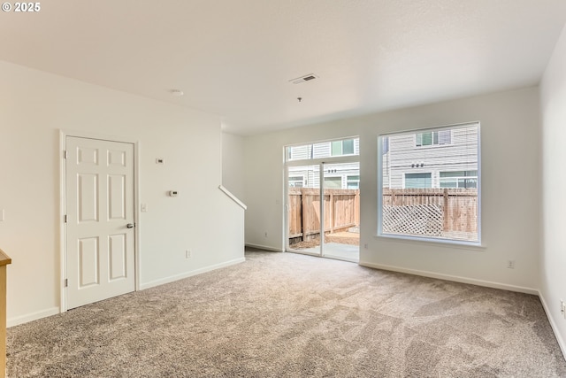 unfurnished room with baseboards, carpet, and visible vents