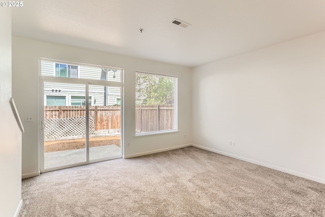 spare room featuring carpet flooring, baseboards, and visible vents