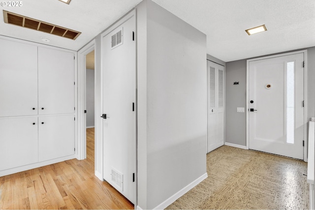 foyer featuring a textured ceiling and light wood-type flooring