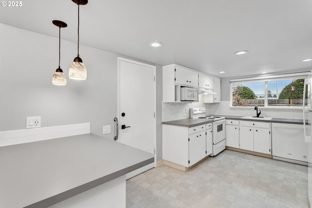 kitchen featuring decorative light fixtures, white cabinetry, sink, decorative backsplash, and white appliances