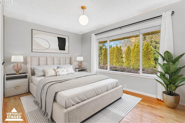 bedroom featuring a textured ceiling and light wood-type flooring