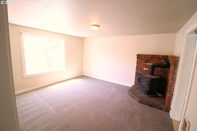 317 S Cedar St, Drain, OR 97435 - unfurnished living room featuring carpet flooring, a wood stove, and a textured ceiling