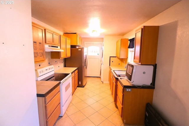 317 S Cedar St, Drain, OR 97435 - kitchen featuring white range with electric stovetop, under cabinet range hood, light tile patterned floors, and freestanding refrigerator