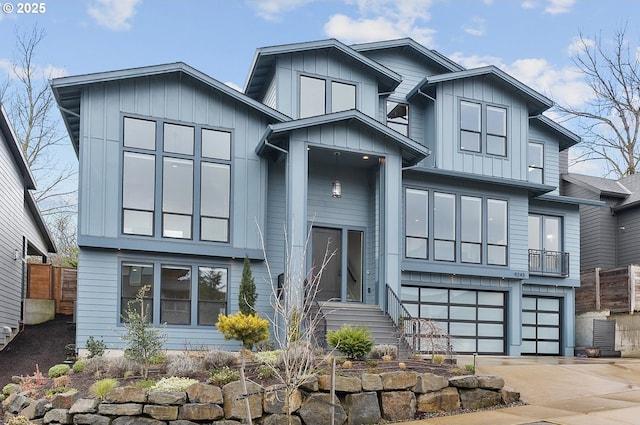 view of front of home with board and batten siding, concrete driveway, a garage, and fence