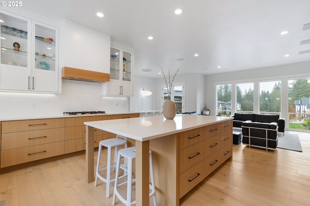 kitchen with gas cooktop, a kitchen island, light wood-style flooring, recessed lighting, and light countertops