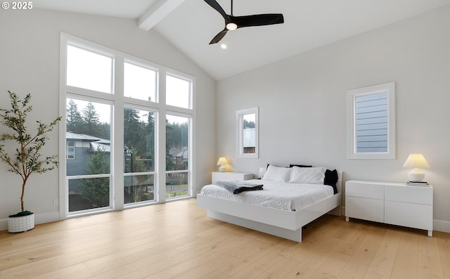 bedroom with beamed ceiling, light wood-style flooring, high vaulted ceiling, and multiple windows