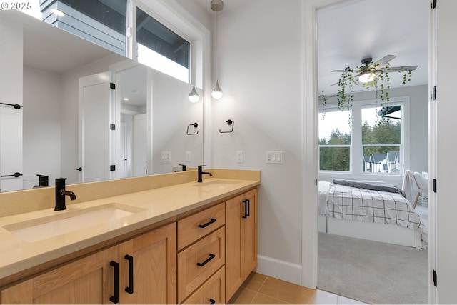 bathroom with a sink, ceiling fan, double vanity, and tile patterned flooring