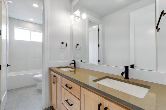 full bath with tile patterned floors, double vanity, toilet, and a sink