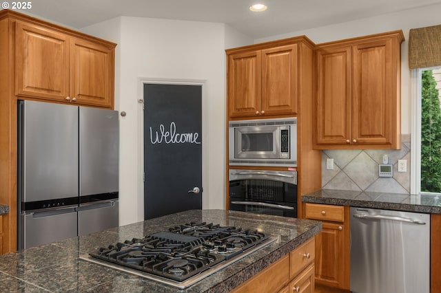 kitchen with recessed lighting, tile countertops, brown cabinets, backsplash, and stainless steel appliances