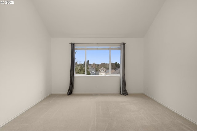spare room with baseboards, light colored carpet, and lofted ceiling