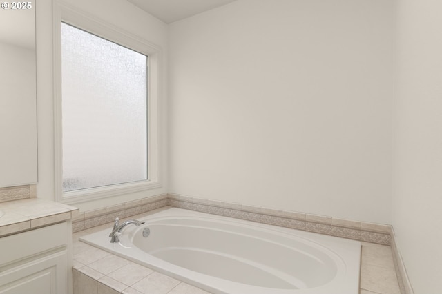 full bath featuring vanity, a garden tub, and a wealth of natural light