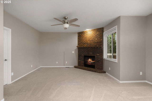 unfurnished living room with baseboards, ceiling fan, light carpet, and a brick fireplace
