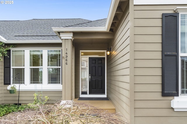 entrance to property featuring a shingled roof