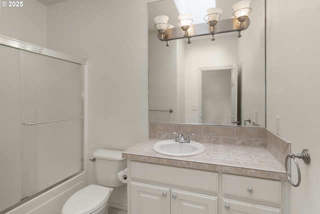 full bathroom featuring toilet, bath / shower combo with glass door, and vanity
