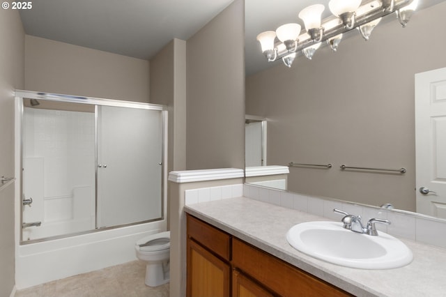 full bath with toilet, combined bath / shower with glass door, tile patterned flooring, and vanity