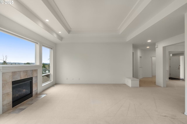unfurnished living room featuring recessed lighting, a tray ceiling, and light carpet