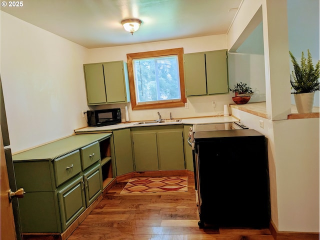 63579 Seven Devils Rd, Coos Bay, OR 97420 - kitchen with green cabinets, black microwave, wood finished floors, and light countertops