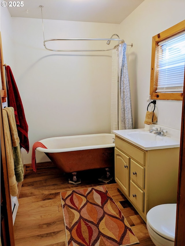 63579 Seven Devils Rd, Coos Bay, OR 97420 - full bathroom with vanity, wood finished floors, a baseboard heating unit, and a combined bath / shower with freestanding tub