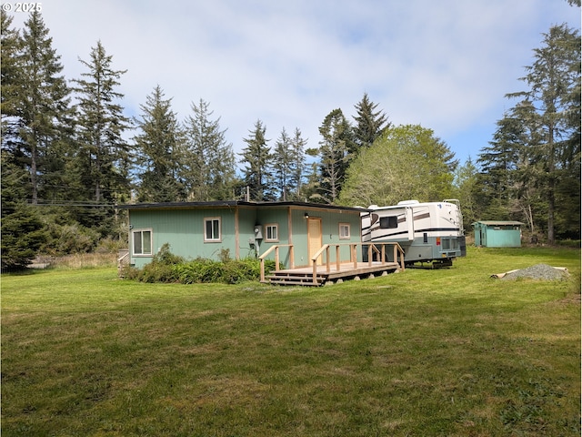 63579 Seven Devils Rd, Coos Bay, OR 97420 - view of front of property with a wooden deck, a front yard, and an outdoor structure