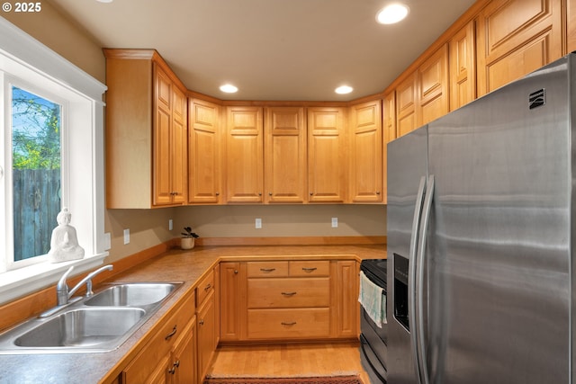 kitchen featuring stainless steel fridge with ice dispenser, a sink, range with electric cooktop, recessed lighting, and light countertops