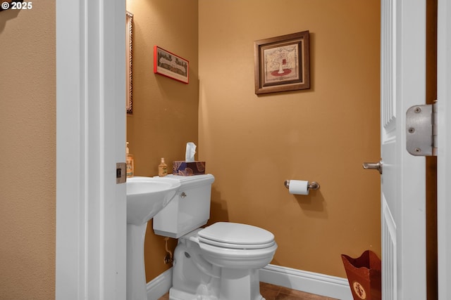 bathroom featuring baseboards and toilet