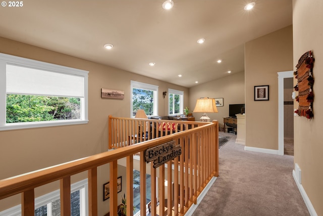 hall featuring light colored carpet, recessed lighting, baseboards, vaulted ceiling, and an upstairs landing