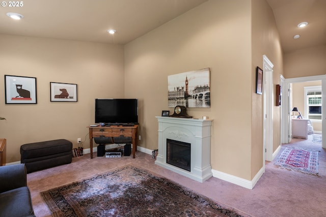 living room with carpet, a glass covered fireplace, baseboards, and recessed lighting