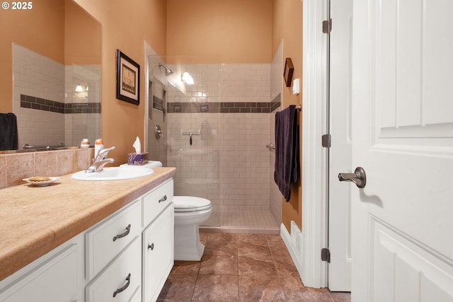 full bathroom featuring tiled shower, vanity, toilet, and tile patterned flooring