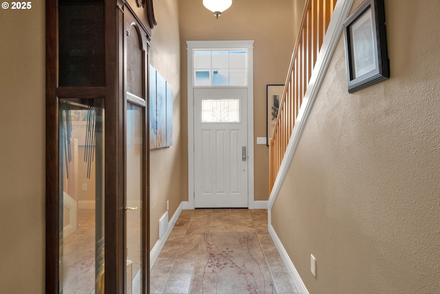 doorway to outside featuring stairs and baseboards