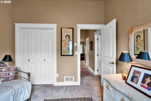 carpeted bedroom featuring a closet and baseboards