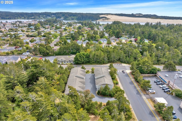 drone / aerial view of a heavily wooded area and a large body of water