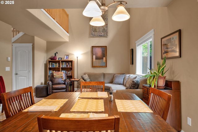 dining space with a towering ceiling and wood finished floors