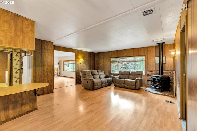 24344 NW Meacham Rd, North Plains, OR 97133 - living area featuring a wood stove, light wood-style flooring, and wood walls
