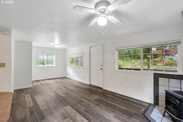 24344 NW Meacham Rd, North Plains, OR 97133 - unfurnished living room featuring a wood stove, wood finished floors, ceiling fan, baseboards, and heating unit