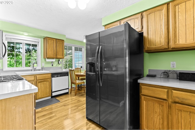 1018 S Holly Ct, Canby, OR 97013 - kitchen featuring refrigerator with ice dispenser, dishwasher, light wood finished floors, light countertops, and a textured ceiling